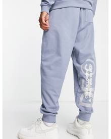 ASOS DESIGN ASOS Dark Future relaxed trackies with logo print in slate blue (part of a set)